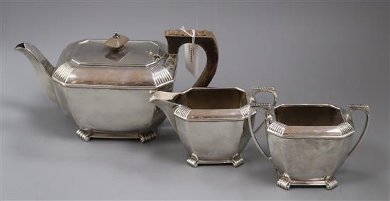 A matched silver three-piece tea service, of shaped rectangular form with reeded corners, handles and feet, approx. gross 35oz.